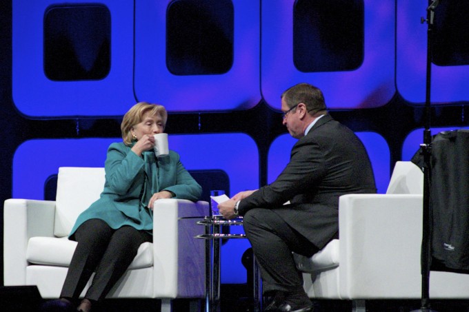 Hillary Clinton drinks coffee on stage.